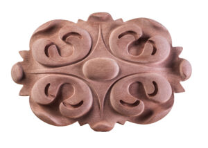 Hand-carved solid wood oval rosette appliqué with symmetrical scroll and volute design on white background