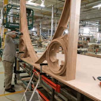 Skilled craftsmen in the shop working on the custom wood fabrication of large-scale Gothic arched tracery, replicating historic custom woodwork for St. Michael's Cathedral Basilica in Toronto.