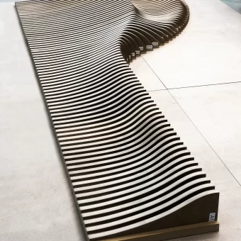 A stunning piece of parametric wall art featuring flowing, wave-like wooden slats, illustrating the intersection of modern design and advanced custom wood fabrication in custom woodwork.
