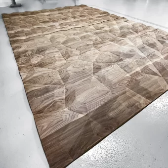 A wide-angle view of "Texture Panel G" laid out for a large-scale project, showcasing a rhythmic, overlapping pattern created through advanced custom wood fabrication and custom woodwork.