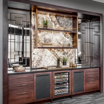A sophisticated built-in bar and counter area featuring the custom wood mullion inserts as decorative glass-front cabinet faces, set against a luxury marble backsplash.