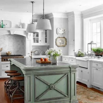 A photograph taken inside a woodworking shop showing the large-scale geometric wood cross-brace before final finishing, highlighting the scale of the custom furniture piece.