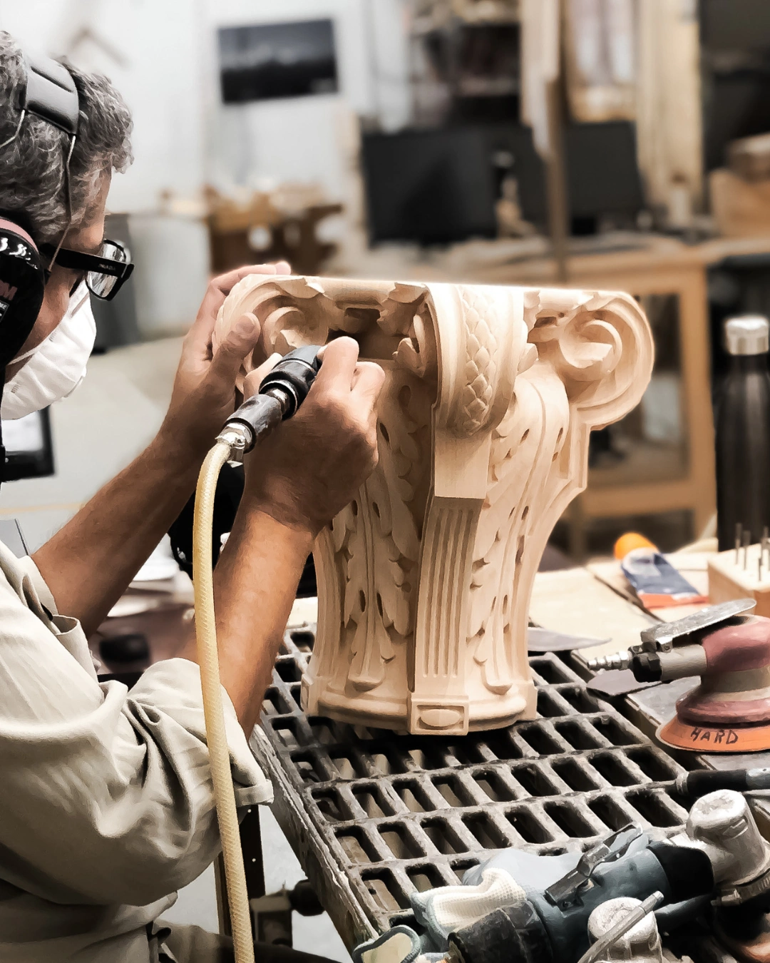 Artisan hand chiseling intricate details on custom carved wood piece